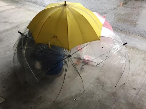雨降る日に傘の下で遊ぶ子供達