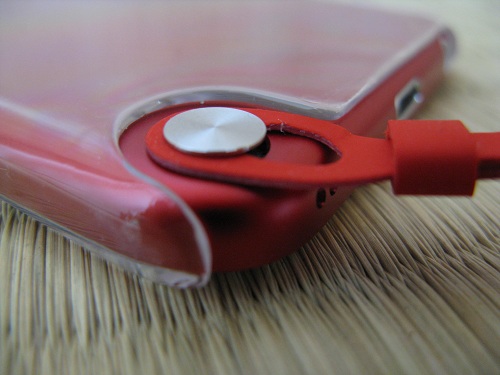 iPod touch 5本体のストラップ（loop）取り付け部分の銀色の円形ボタンの支柱に引っ掛けられたストラップ（loop）（装着完了）