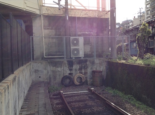 正覚寺下電停の途切れた線路の先にある壁とタイヤ