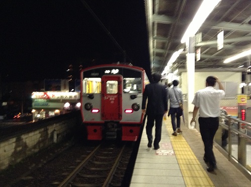 JR別府駅（大分県別府市駅前町）の1番ホームに到着しつつある23時52分発の普通列車に近づく人々