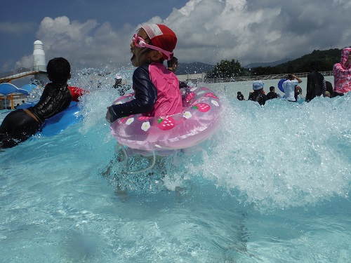 南レクジャンボプール（愛媛県南宇和郡愛南町御荘平城728）の造波プール（人工の波がくるプール）の波で遊ぶ娘