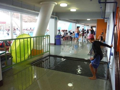イヨテツスポーツセンターのプールの足洗い場に及び腰で入る小学6年生の娘