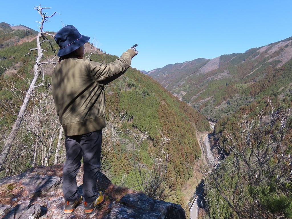 広田石鎚(総津権現山)35:山頂近くの崖の上から見える山の景色を指差して解説する娘