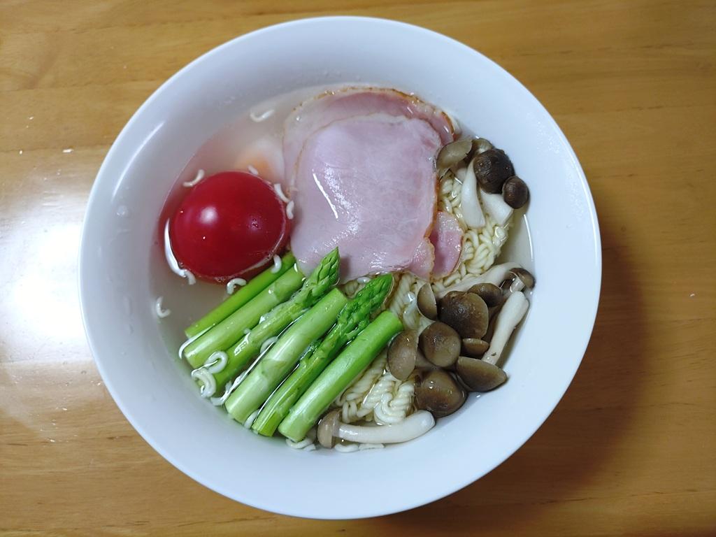 電子レンジ調理後のレンジ対応食器＋袋麺「サッポロ一番 みそラーメン」の麺＋水＋トマト＋生卵＋アスパラガス＋ロースハム＋ぶなしめじ