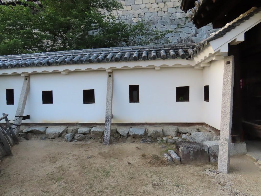 四角形の鉄砲狭間がある松山城の白い土塀