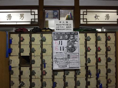 東京都荒川区の銭湯・玉の湯の玄関にある傘入箱とガラス窓に記載された男湯と女湯の表示