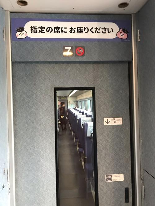 西武新宿駅2番線ホームに停車中の「カナヘイの小動物 ゆるっと小旅 西武鉄道で行く川越旅」のラッピング列車(7号車両自動ドア上のピスケ、ピンクのうさぎからのメッセージ)