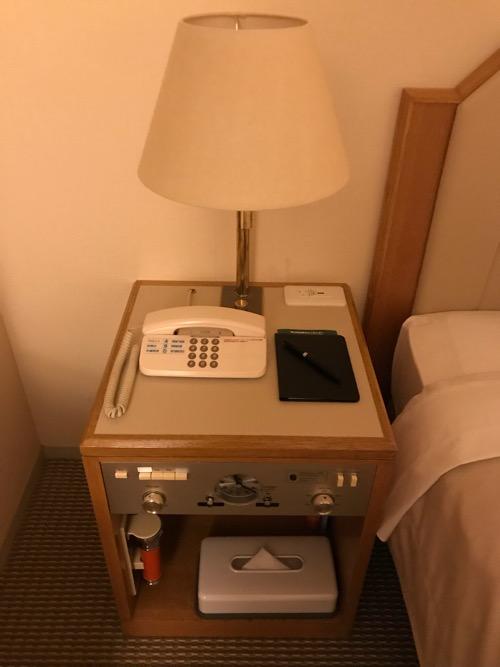 ホテルニューオータニ高岡の客室入口から見た禁煙シングルルームのベッドの横の照明、ルーム電話機