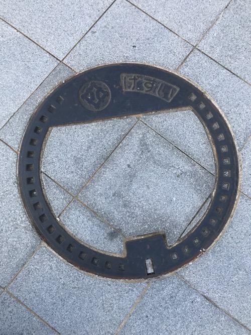 福井県福井市の「げすい」と書かれた周辺の道の石模様が付いたマンホールの蓋