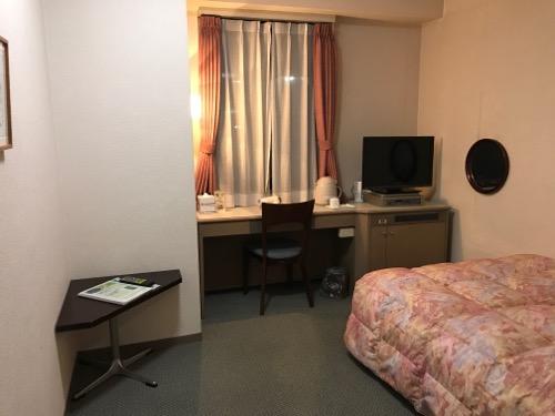 ホテルエコノ金沢駅前のシングルルームの机、椅子、ベッド