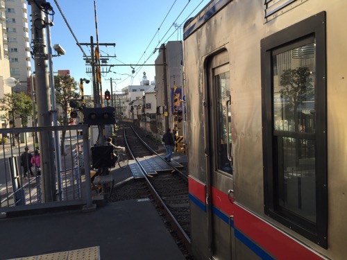 京成金町駅ホームの端から見た目前の踏切と停車中の電車
