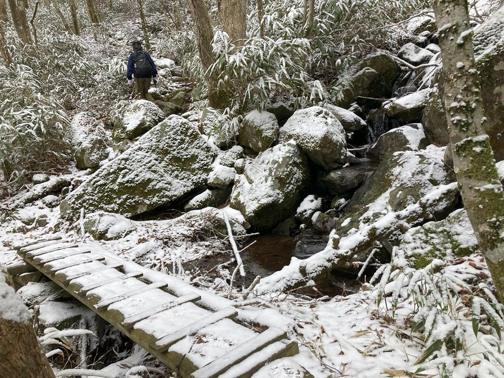 皿ヶ嶺畑野川ルート7：雪の山道を歩く娘、小川の上にかかる橋