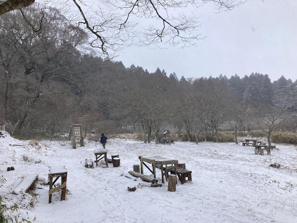 皿ヶ嶺 竜神平1：竜神平の標識に向かって雪原をあるく娘。テーブルと椅子