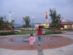 「エミグルメの噴水」前を手をつないで歩く妻と浴衣姿の3歳4ヶ月の娘
