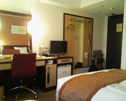 「ホテル法華クラブ福岡」のシングルルーム室内にある机、椅子、液晶テレビ、ベッド