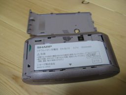 WILLCOM SHARP W-ZERO3 WS003SH(S)の本体背面よりバッテリーカバーを取り外した写真1